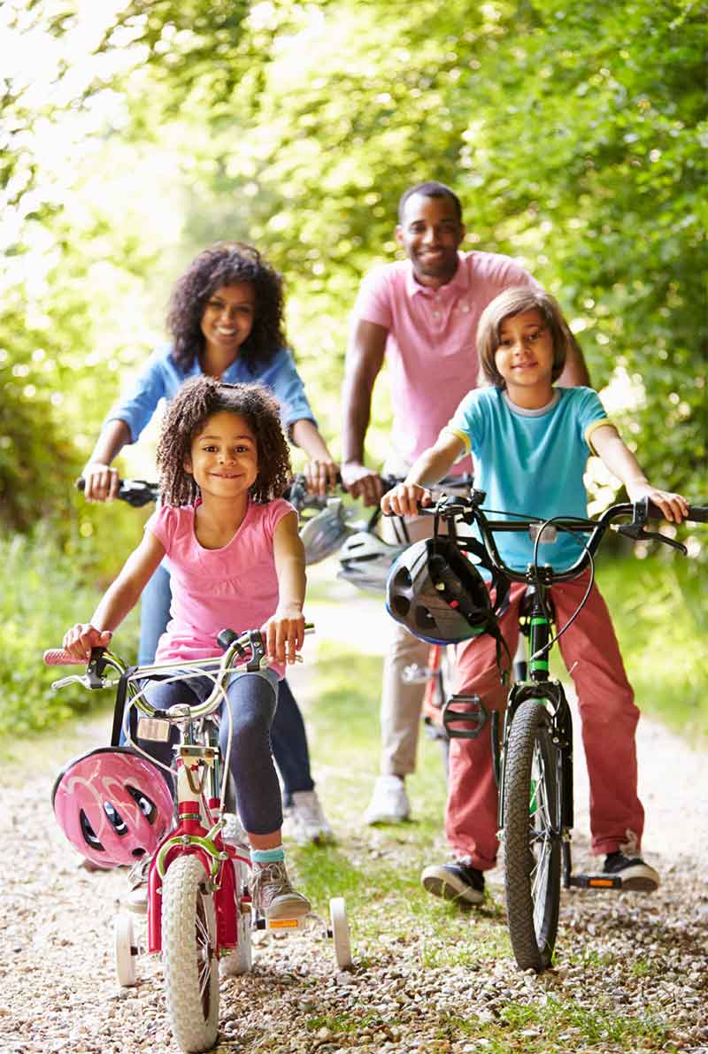 family taking a bike ride through park
