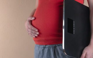 pregnant woman holding scale