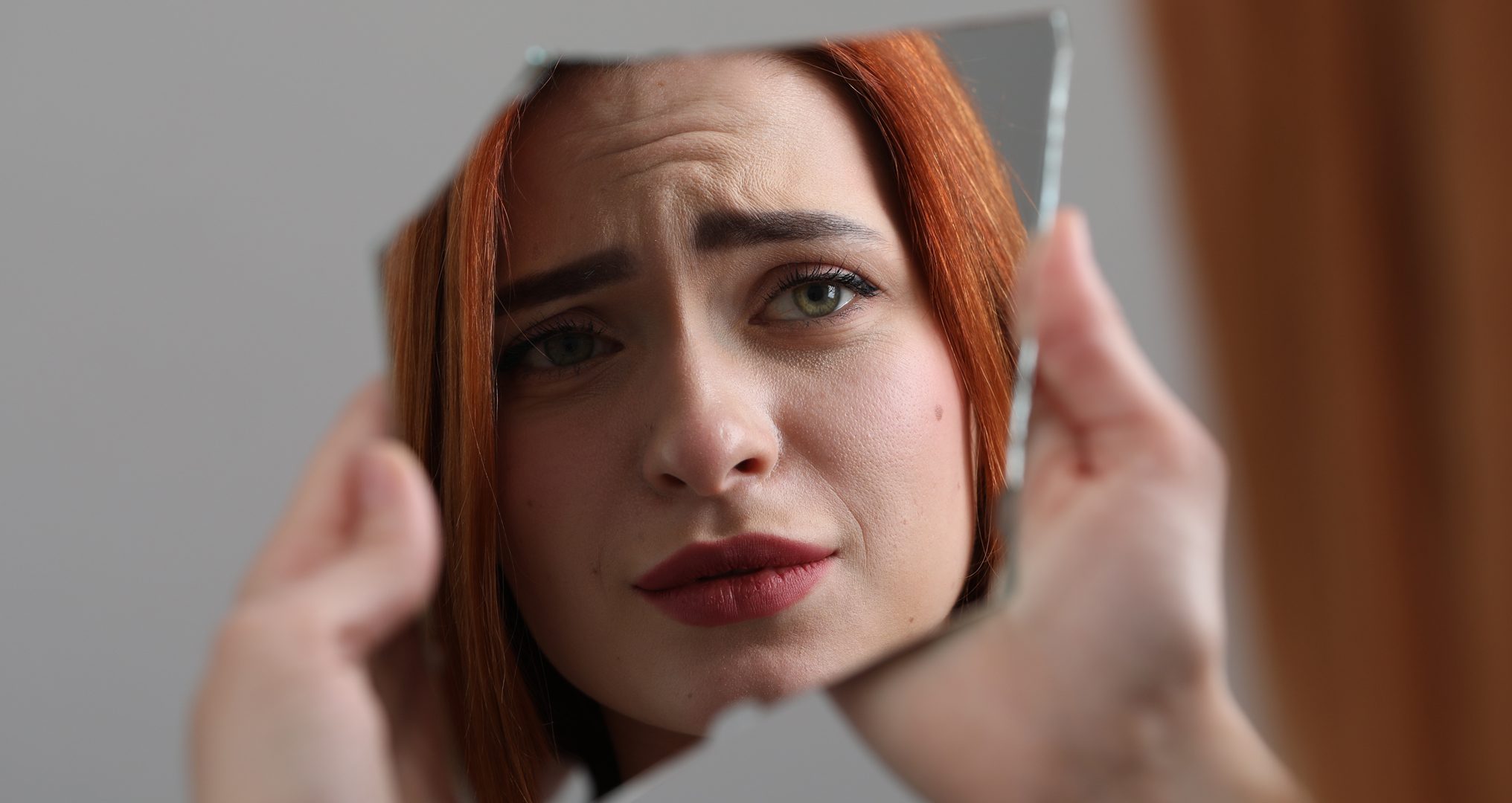 Woman looking at herself in mirror