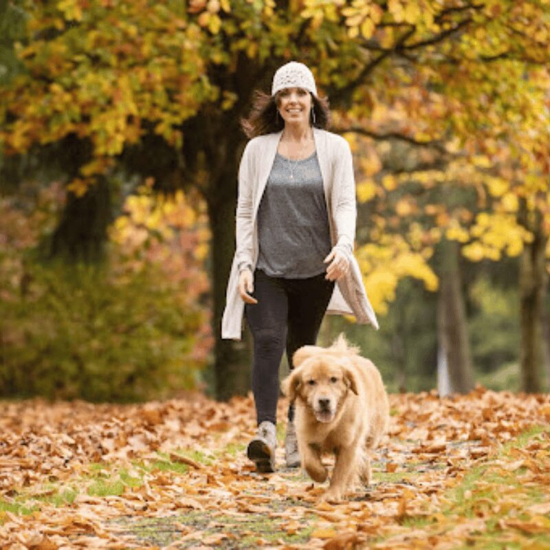 woman walking with her dog in the woods